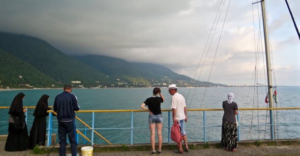 nuns-watch-as-a-charter-boat-takes-russian-tourists-from-the-pier-of-gagra
